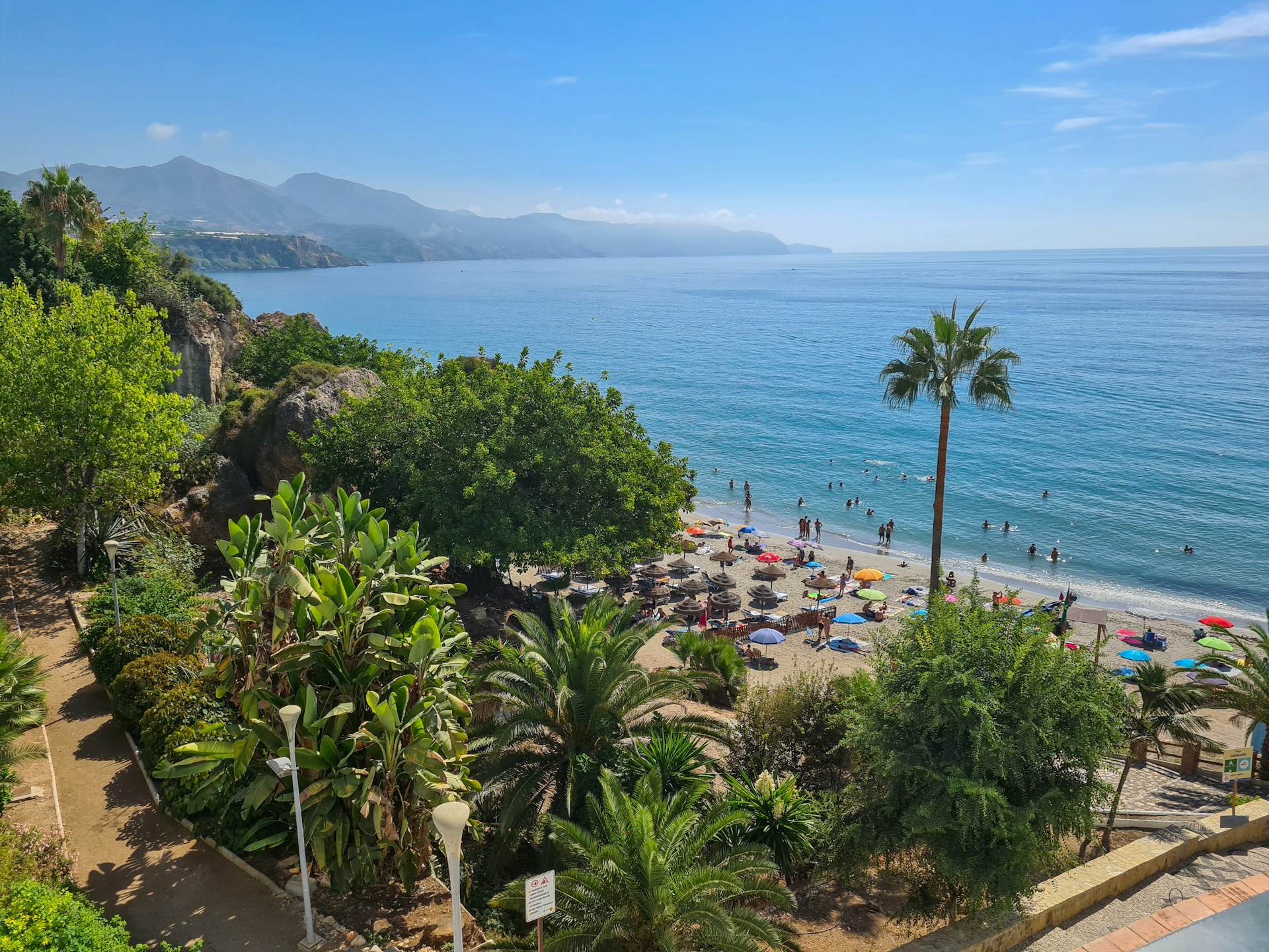 Panoramaudsigt over Playa de Burriana med solsenge, palmer og turkist hav